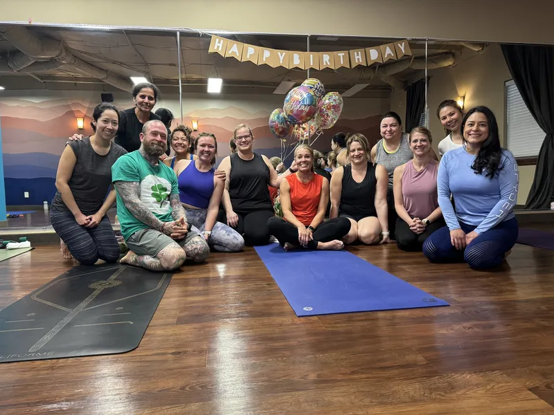 Members gathered on the mats in our studio under a Happy Birthday banner and balloons